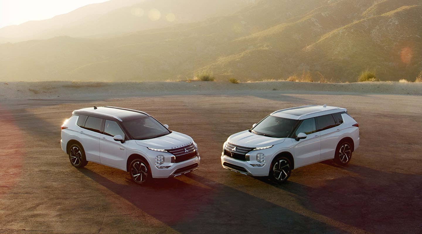 2023 Mitsubishi Outlander SUV and Outlander PHEV SUV in white parked in the desert