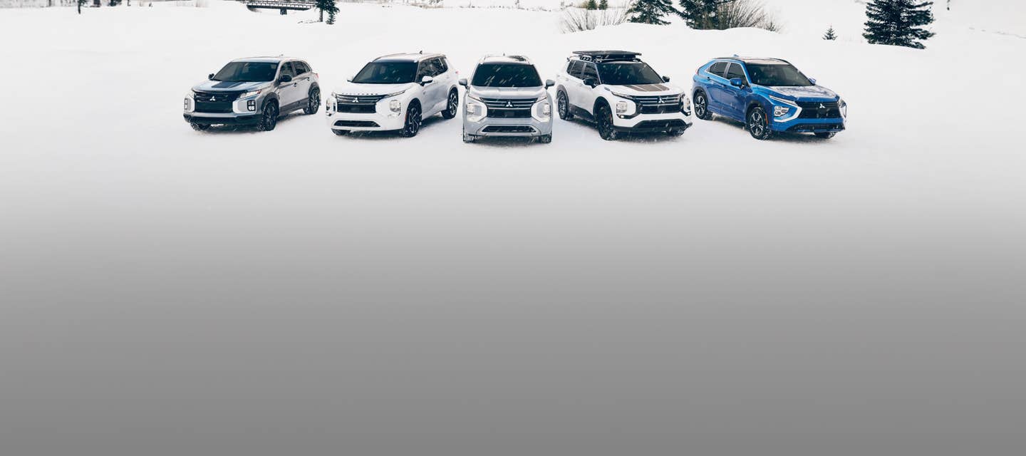 A lineup of Mitsubishi SUVs in the snow